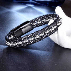 Gros plan d'un bracelet tressé en cuir noir pour homme avec chaîne argent et fermoir magnétique