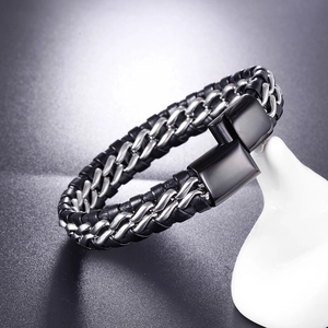 Gros plan sur le bracelet tressé en cuir noir et chaîne en métal argenté avec fermoir aimanté