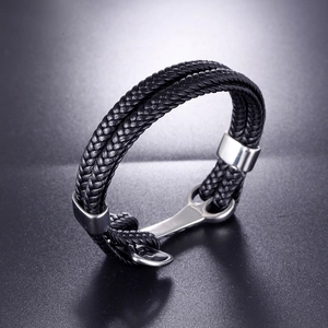 Detail shot of black braided leather men's bracelet with silver anchor metal clasp