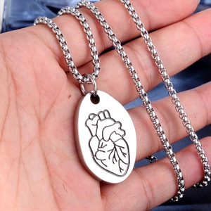 Dettaglio dell'incisione anatomica del cuore su ciondolo ovale in acciaio inossidabile