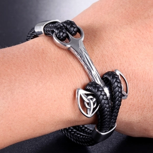 Detail of men's braided leather bracelet with Nordic silver metal celtic knot charm