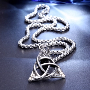 Macro shot of silver Celtic Triquetra knot pendant with industrial style link chain