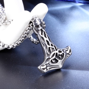 Macro shot of Viking Mjölnir pendant with vintage Norse engravings on box chain