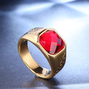 Detailed view of golden ring featuring square red stone and engraved side patterns