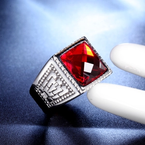 Macro shot of men's signet ring with red gemstone and intricate geometric patterns