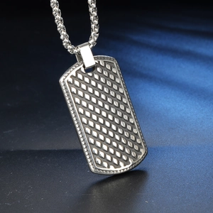Vue macro d'un pendentif rectangulaire argenté avec motif diamant sur une chaîne à billes