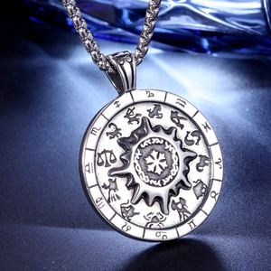 Gros plan sur le pendentif boussole soleil vintage en acier avec signes du zodiaque