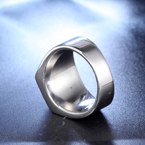 Macro shot of silver stainless steel hexagonal ring on a textured black surface