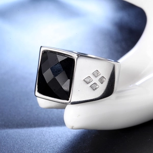 Macro view of men's stainless steel ring featuring a large faceted black glass stone