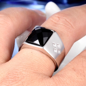 Macro shot of men's silver stainless steel ring featuring a square black gemstone inlay