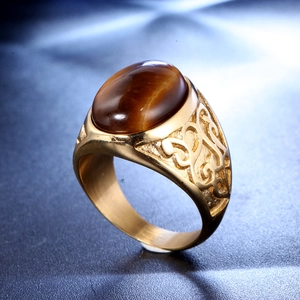 Macro view of vintage gold-plated men's ring featuring an oval tiger eye gemstone inlay