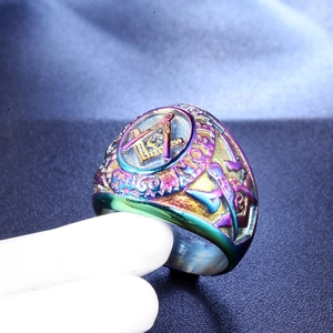 Macro shot of rainbow plated Freemasonry ring showing the square and compass engraving