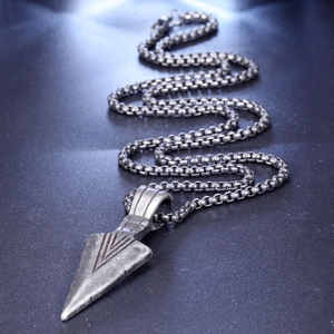 Detailed close-up of retro stainless steel arrowhead pendant with vintage box chain