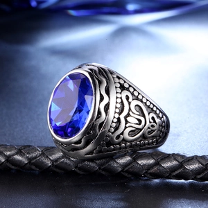Macro d'une bague vintage pour homme en acier inoxydable avec pierre bleue et gravures