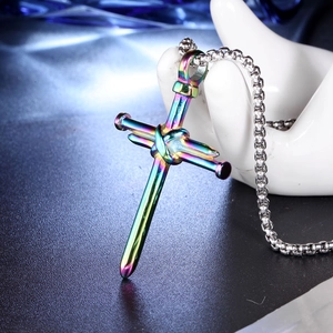 Gros plan d'un pendentif croix clou en acier inoxydable arc-en-ciel sur chaîne à boules