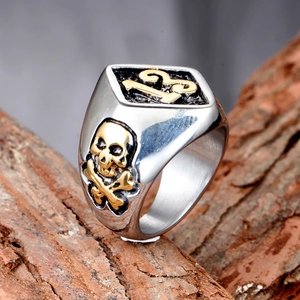 Dettaglio anello punk con numero 13 dorato ed emblema del teschio su legno testurizzato