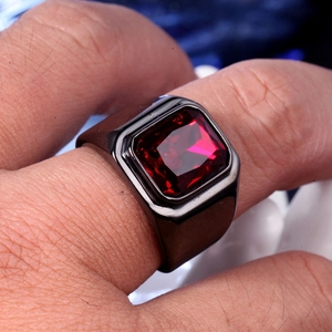 Gros plan d'une bague noire pour homme avec une grande pierre rouge carrée