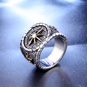 Vintage stainless steel anchor ring with gold compass star from a 45-degree angle view