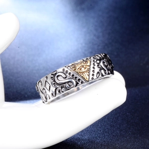 Macro shot of vintage Freemason All Seeing Eye ring on white ceramic hand display