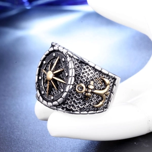 Vintage nautical titanium steel ring with gold compass and anchor on white hand stand