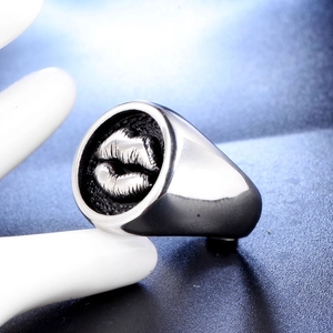 Macro shot of polished silver stainless steel ring with 3D lip emblem on display