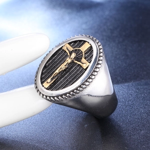 Vintage stainless steel mens signet ring featuring a golden cross on black textured oval face