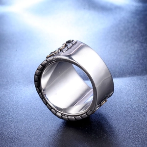 Macro shot of wide titanium steel ring with gold relief details and punk textured edges