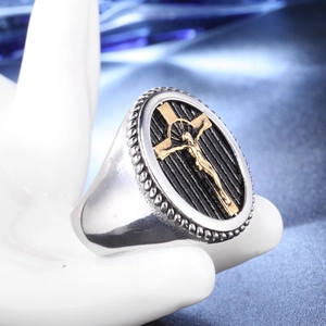 Macro shot of vintage silver ring with golden Jesus cross relief and black stripes