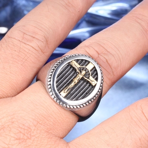Detailed view of a vintage oval ring with a gold Jesus crucifix on a black background