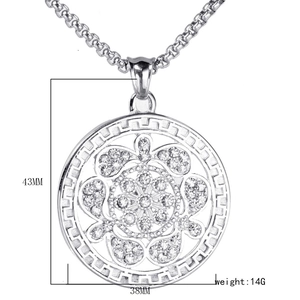 Détail du pendentif arbre de vie argenté avec strass et bordure à motif grec