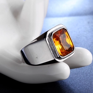 Detail of a men's stainless steel signet ring with a large orange rectangular gemstone