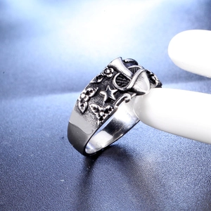 Detailed macro shot of vintage punk skull ring with carved stars and mushroom patterns
