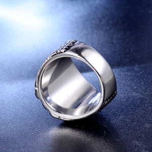 Macro detail of men's stainless steel compass ring with textured retro mechanical design