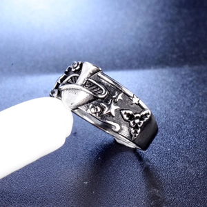 Detailed close-up of retro wide metal ring featuring embossed mushroom and star patterns