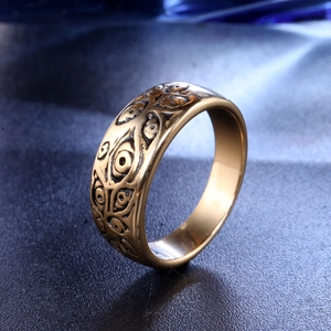 Detailed close-up of golden titanium steel ring featuring vintage multi-eye totem patterns