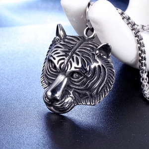 Close-up of vintage stainless steel tiger head pendant with a rugged polished finish