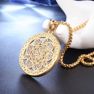 Détail macro du pendentif fleur dorée avec cristaux et chaîne à mailles box