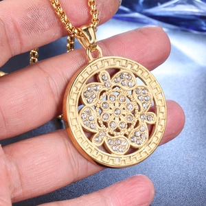 Détail du pendentif arbre de vie doré serti de zircons avec motif de clé grecque