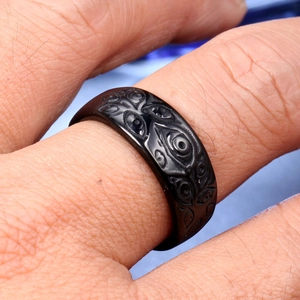 Vintage black titanium steel ring with eye relief pattern shown on a finger