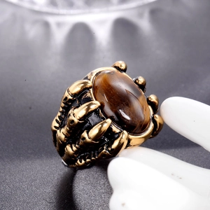 Macro shot of punk claw ring with oval tiger eye stone in vintage gold finish