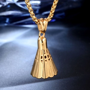 Macro d'un pendentif volant de badminton doré poli sur une chaîne en maille vénitienne