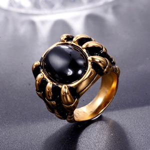 Macro shot of men's vintage gold ring with dragon claw holding a large black stone