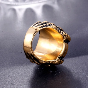 Macro shot of gold-plated men's ring with black dragon claw textures and polished inner band