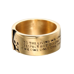 Macro view of gold punk ring featuring skull relief and engraved vintage lettering