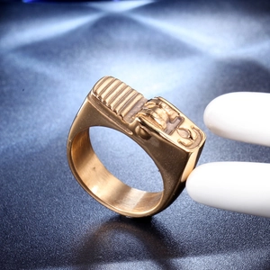 Close-up of golden vintage lighter-shaped ring with industrial wheel detail on finger