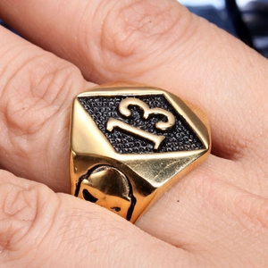 Macro shot of gold stainless steel ring with 13 emblem and side skull relief details