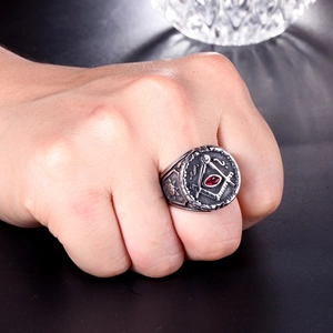 Gros plan de la bague maçonnique avec symbole compas et pierre marquise rouge incrustée