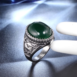 Dettaglio macro dell'anello vintage argento con gemma ovale verde e rilievi incisi