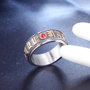 Mens stainless steel spinning ring with gold mantra relief and red crystal accent