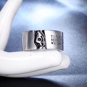 Primer plano de un anillo de calavera plateado con grabado en un maniquí de mano blanca